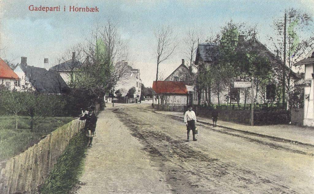 Hornbæk Hovedgade, 1897, hvor købmandsgården netop er opført og man ser det første udsalg med rødt tag fra 1889, hvor senere Gemüse Carls forretning kommer.